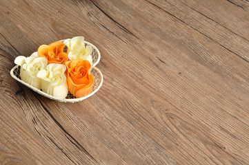 A heart shape wire basket filled with orange and white rose shap