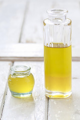 Big bottle and small jar of golden liquid