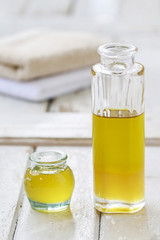 Big bottle and small jar of golden liquid