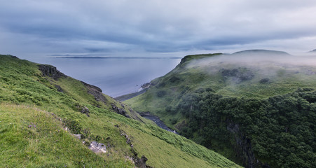 Green hills near the ocean on Isle of Skye in mist