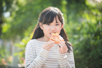 Beautiful Asian girl eating eating pizza