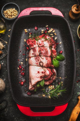 Raw lamb shoulder roast with string , herbs and spices on red baking tray, top view. Meat food.