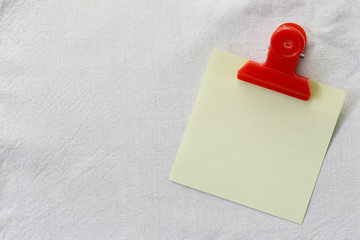 yellow of note paper placed on White fabric background.
