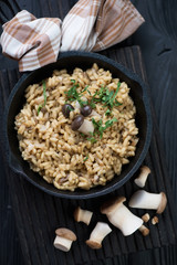 Risotto with porcini mushrooms and parsley in a skillet, closeup