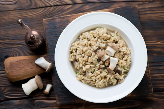Risotto with porcini mushrooms over rustic wooden background