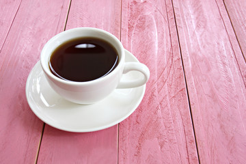 hot coffee in a white Coffee cup on pink wooden table.
