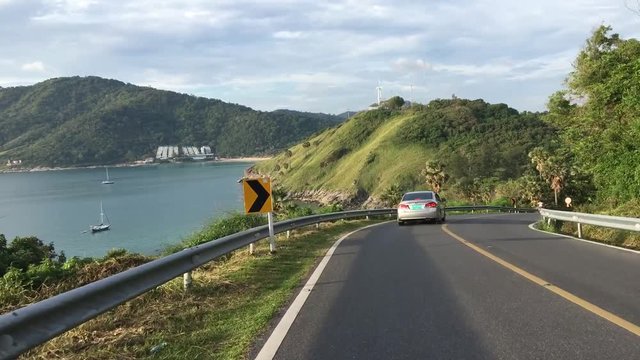 Vehicle driving shoot from car on mountain road in Thailand beautiful sea view