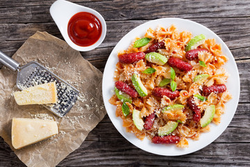 sausages bowtie Pasta warm salad with avocado slices and cheese