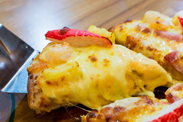 seafood cocktail pizza on wood plate.