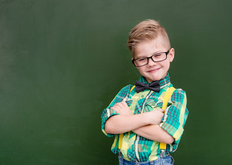 Funny happy nerd near empty green chalkboard