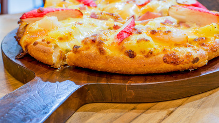 seafood cocktail pizza on wood plate.