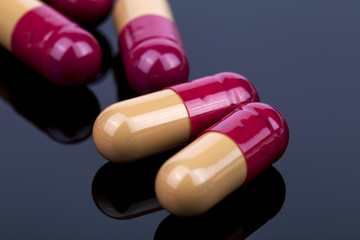 Orange pills on the black background