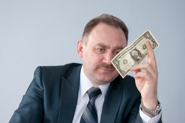 Male looks at a dollar in his hand 