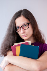 Girl in glasses holding a book in their hands  