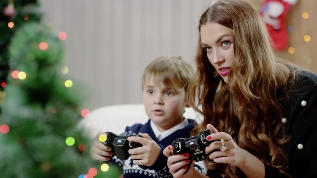 son and mother playing video game on playstation