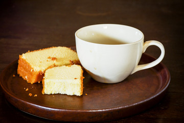 Coffee cup with half of coffee left and two pieces of butter cake