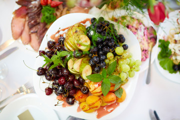 tasty fruit on a plate with pears, grapes, apricots