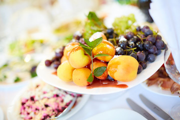 tasty fruit on a plate with pears, grapes, apricots