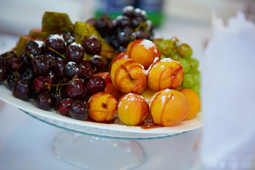 Naklejka na ściany i meble tasty fruit on a plate with pears, grapes, apricots