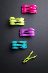 Colored laundry clips over a black background above view