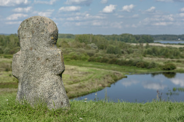 ancient stone religious cross on a hill in background of the river
