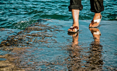 Man legs and feet  at the sea shore