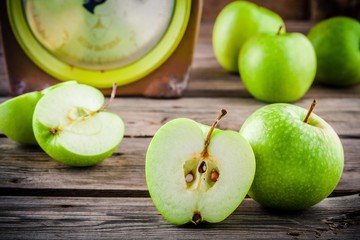 organic green apples in colander on rustic wooden background