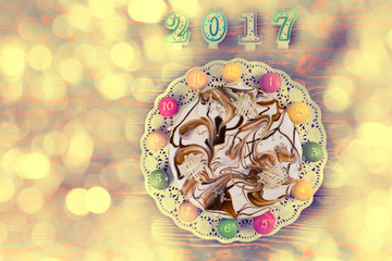 New year cake and macarons as a clock near candles number 2017 o