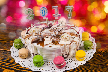 Cake for new year with candles number 2017 on wooden desk, brigh