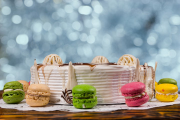 Fototapeta na wymiar Close up of cake with different chocolate ornaments, near macaro