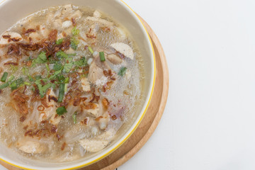 Traditional Vietnamese Noodle pork soup on a wooden background.
