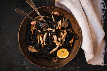 Black pasta, noodles with shimeji mushrooms cast iron. Healhty eating.