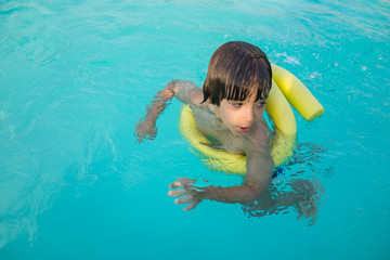 Young boy kid child splashing in swimming pool having fun leisur
