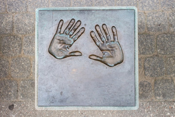 hands in bronze plate