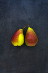 Two whole red yellow pears isolated on gray slate stone backgrou