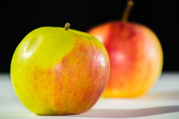 Red and green apple fruit on a white black background