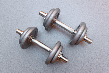 Obraz na płótnie Canvas two sports dumbbells on a grey background