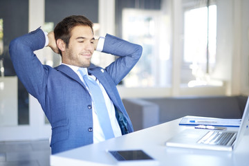 Successful in work. Shot of a successful financial professional man sitting in his workstation and...