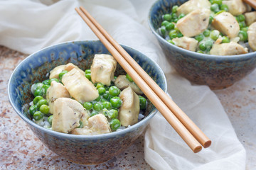 Fried chicken with green peas in cream sauce, served with rice, horizontal