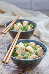 Fried chicken with green peas in cream sauce, served with rice, vertical