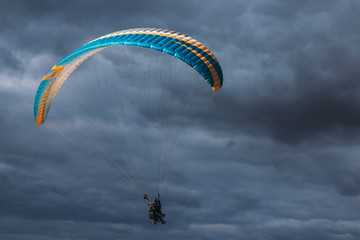 Paraglider in the dark blue sky
