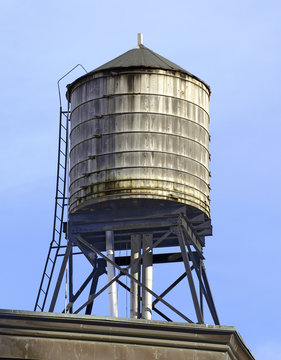 Vintage wooded water tanks on roof of apartment building in New York City hold water that is sourced from the Catskill Mountains