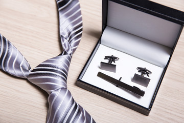 tie and cufflinks on wooden table