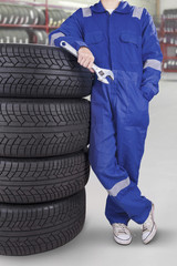 Male technician with pile of tires