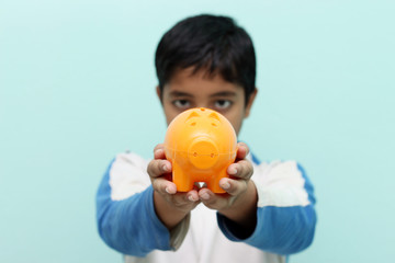 Boy holding piggy bank in his hand.