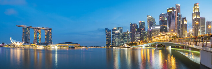Fototapeta na wymiar Colorful Singapore business district skyline after sun set at Marina Bay. Panoramic image.
