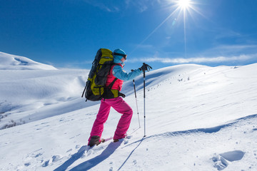 Woman is hiking in snowy winter mountains
