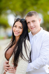 Portrait of beautiful young couple in love, background outdoor