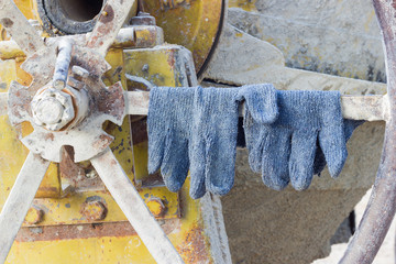 pair of gloves on the cement mixer in the construction site