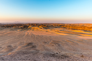 Sunset light over barren valleys and canyons, known as "moon landscape", Namib desert, Namib Naukluft National Park, among the most important travel destination in Namibia, Africa.